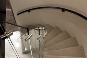 Custom glass panels were individually installed to mirror the curve of the staircase and maximize the view of the apartment while descending.