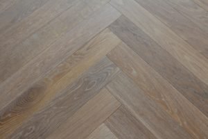 A photo of the herring bone pattern floor illustrates how well the floor was installed and the beauty of the client-chosen material.