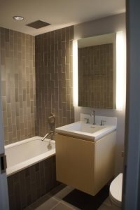 A vertical brick tile design lends a unique spin to this guest bathroom.