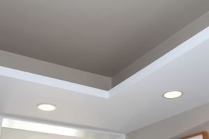 To preserve existing ceiling height and add light, a tray effect was added in which recessed lights could be installed. The result is a layered look above with light shining down below.