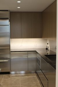 Alternate material and color was installed for the upper kitchen cabinets to continue the contrast theme playing out in the rest of the home.