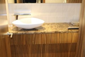 A surface-mounted oval sink adds the needed contrast to the perfect lines of the overall room.